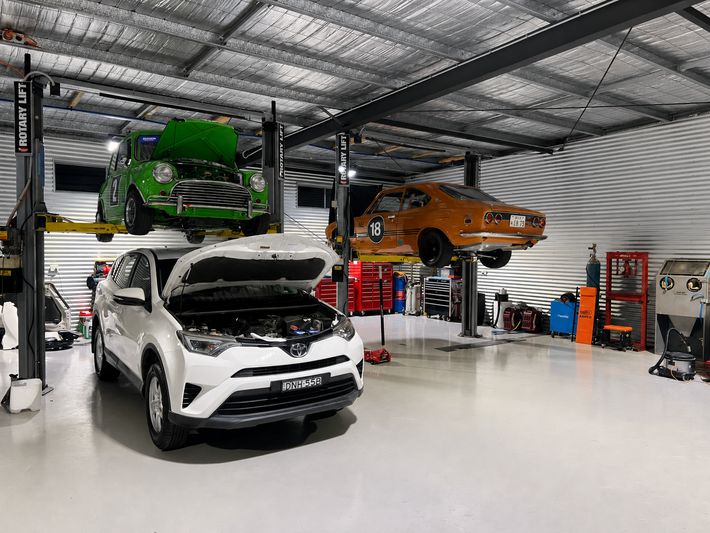 Inside the Fix'd By workshop — multiple vehicles on rotary lifts